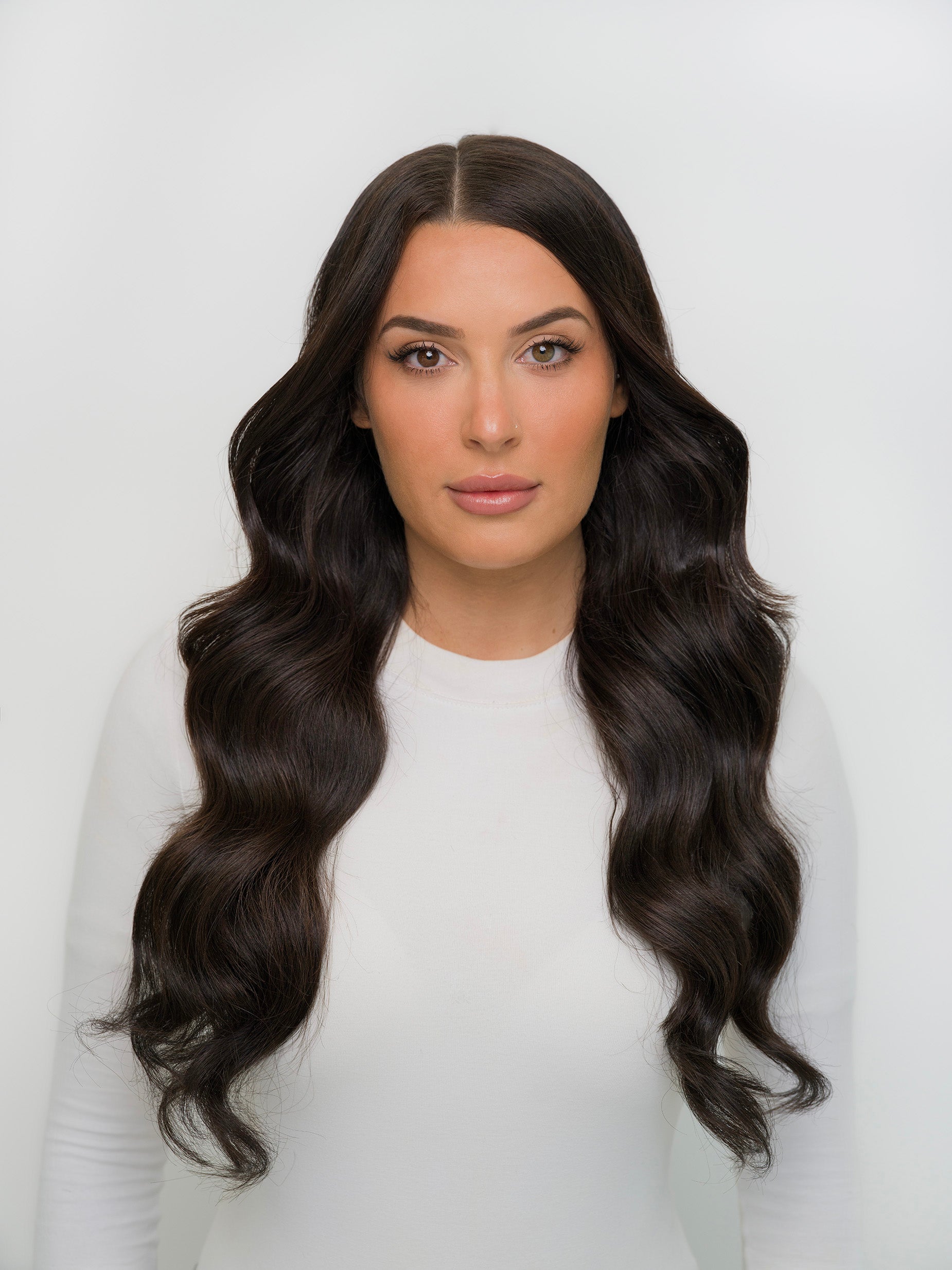 Woman with long, wavy hair in darkest brown showcasing Extra Hair Extension Piece - Darkest Brown #1A for seamless blend.