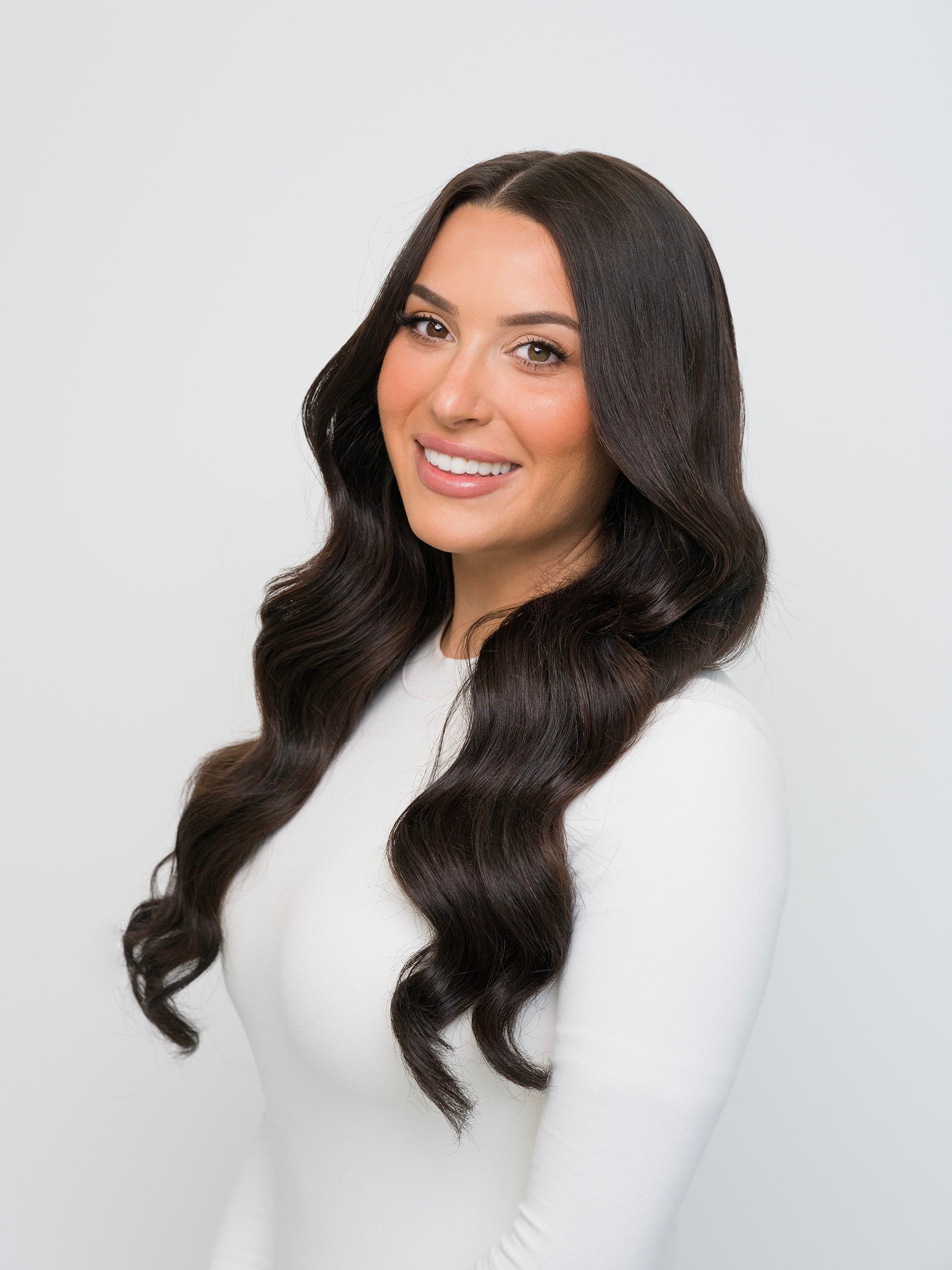 Smiling woman with long, wavy dark hair showcasing Extra Hair Extension Piece - Darkest Brown 
