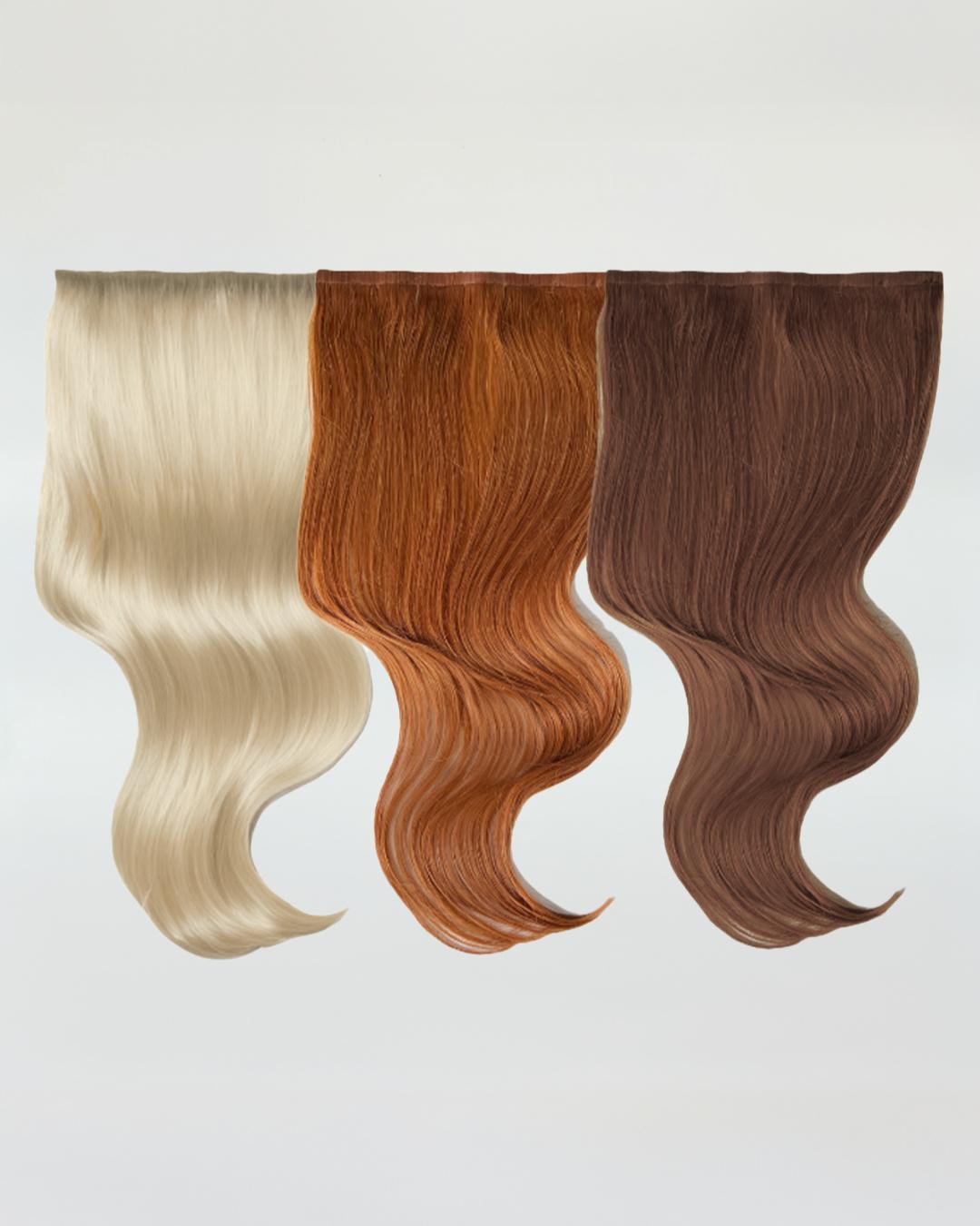 Three wavy hair extensions in light blonde, copper red, and medium brown shades hanging against a white background