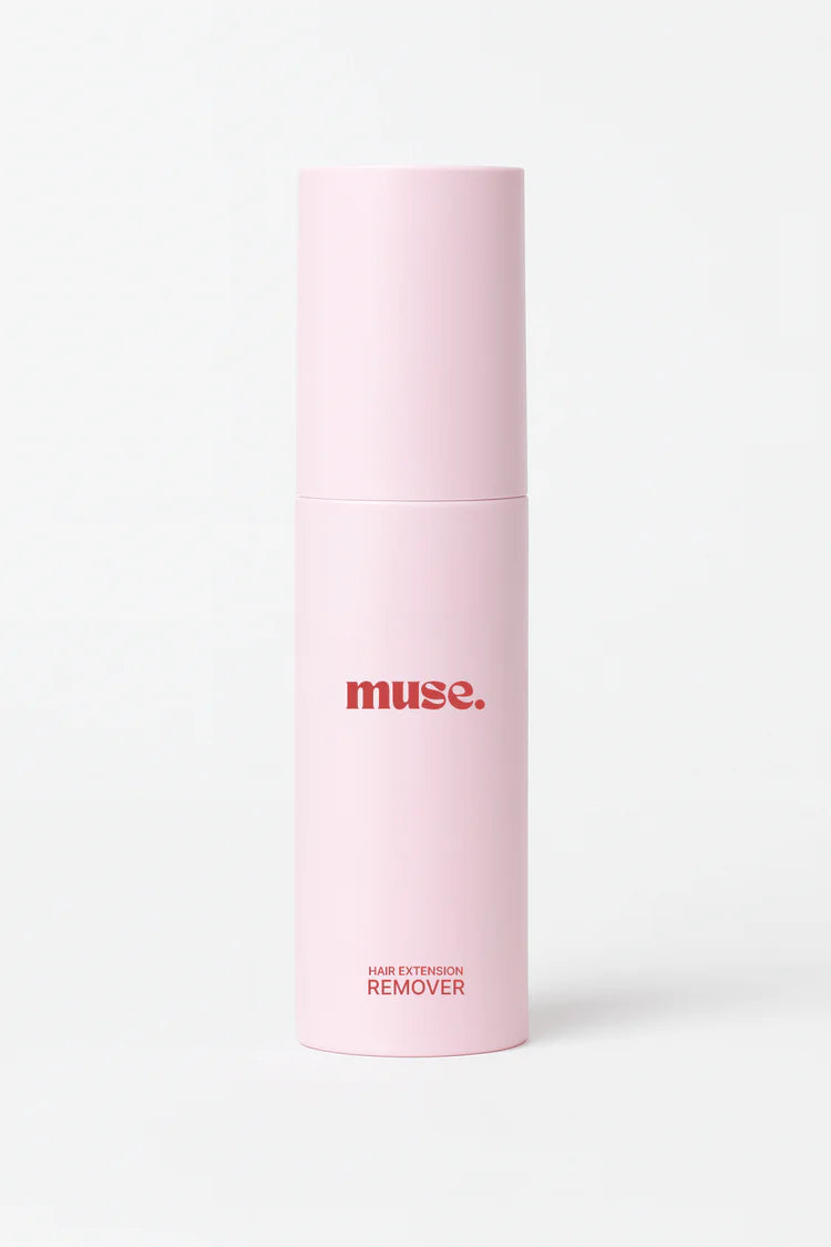 Tall pink bottle with red text labeled muse hair extension remover on a plain white background