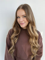Smiling woman with long wavy hair showcasing Extra Hair Extension Piece - Brown 
