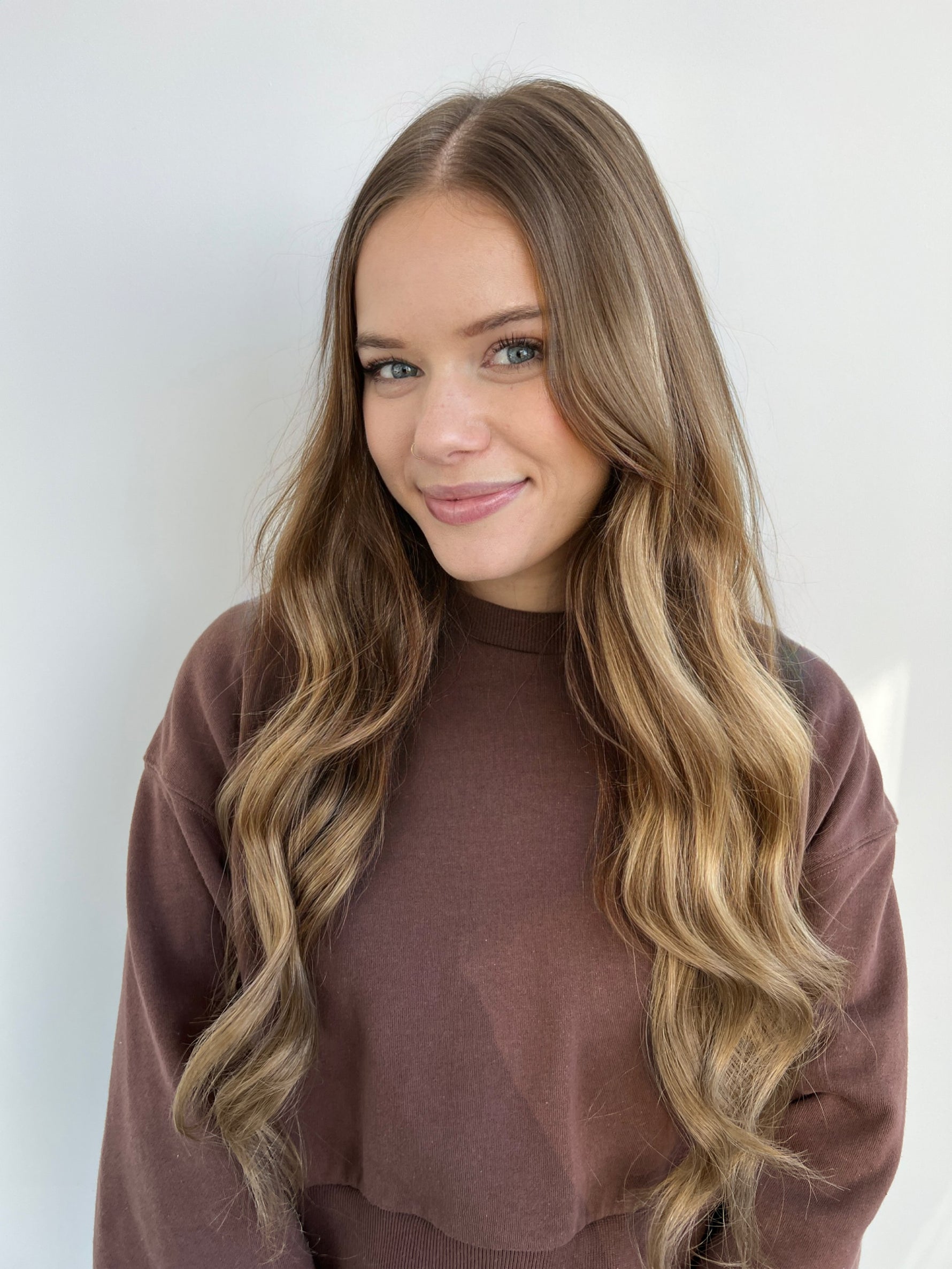 Smiling woman with long wavy hair showcasing Extra Hair Extension Piece - Brown 