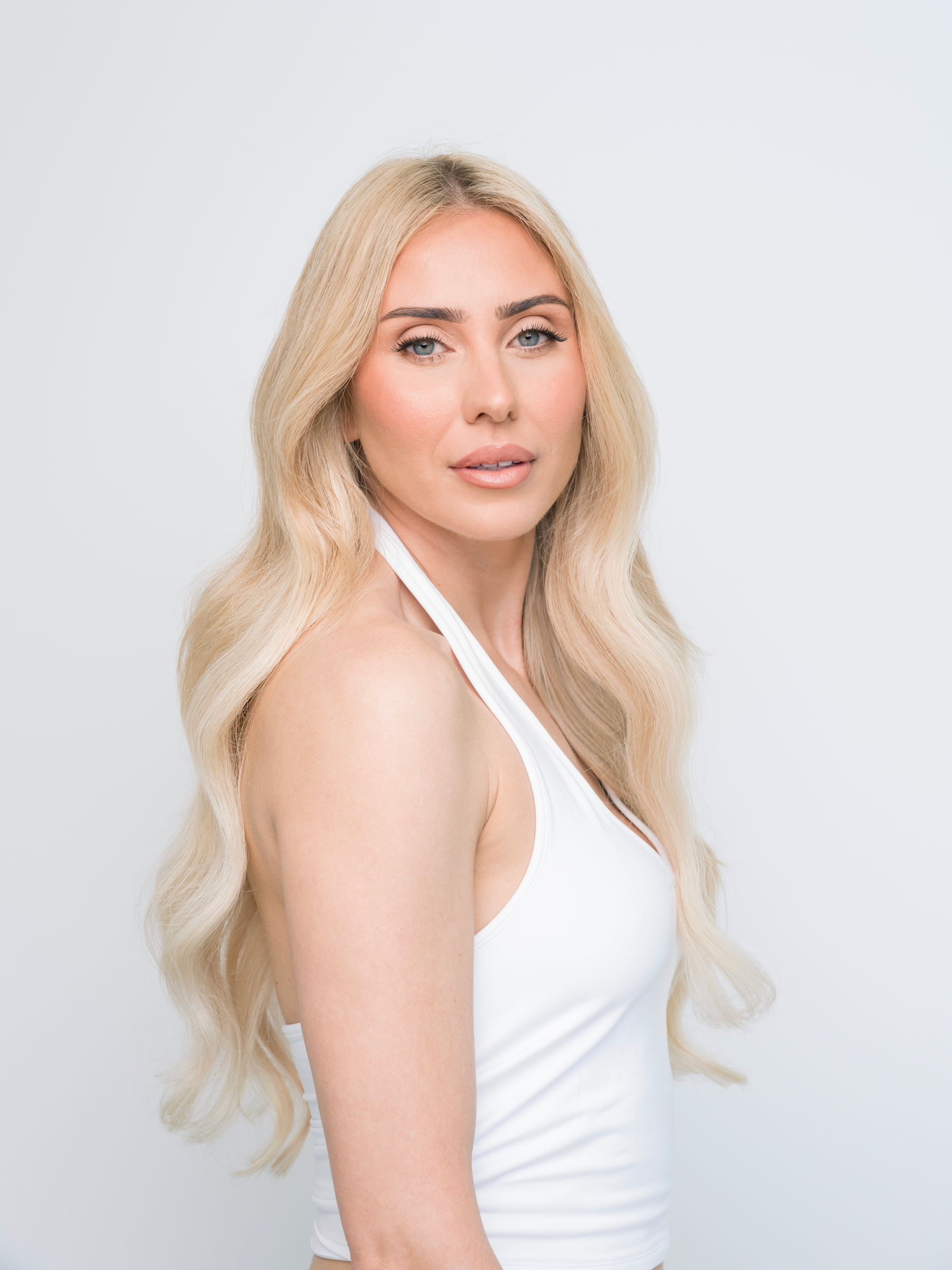 Woman with long wavy blonde hair wearing Extra Hair Extension Piece - Bohemian Blonde #P18A/60 styled naturally