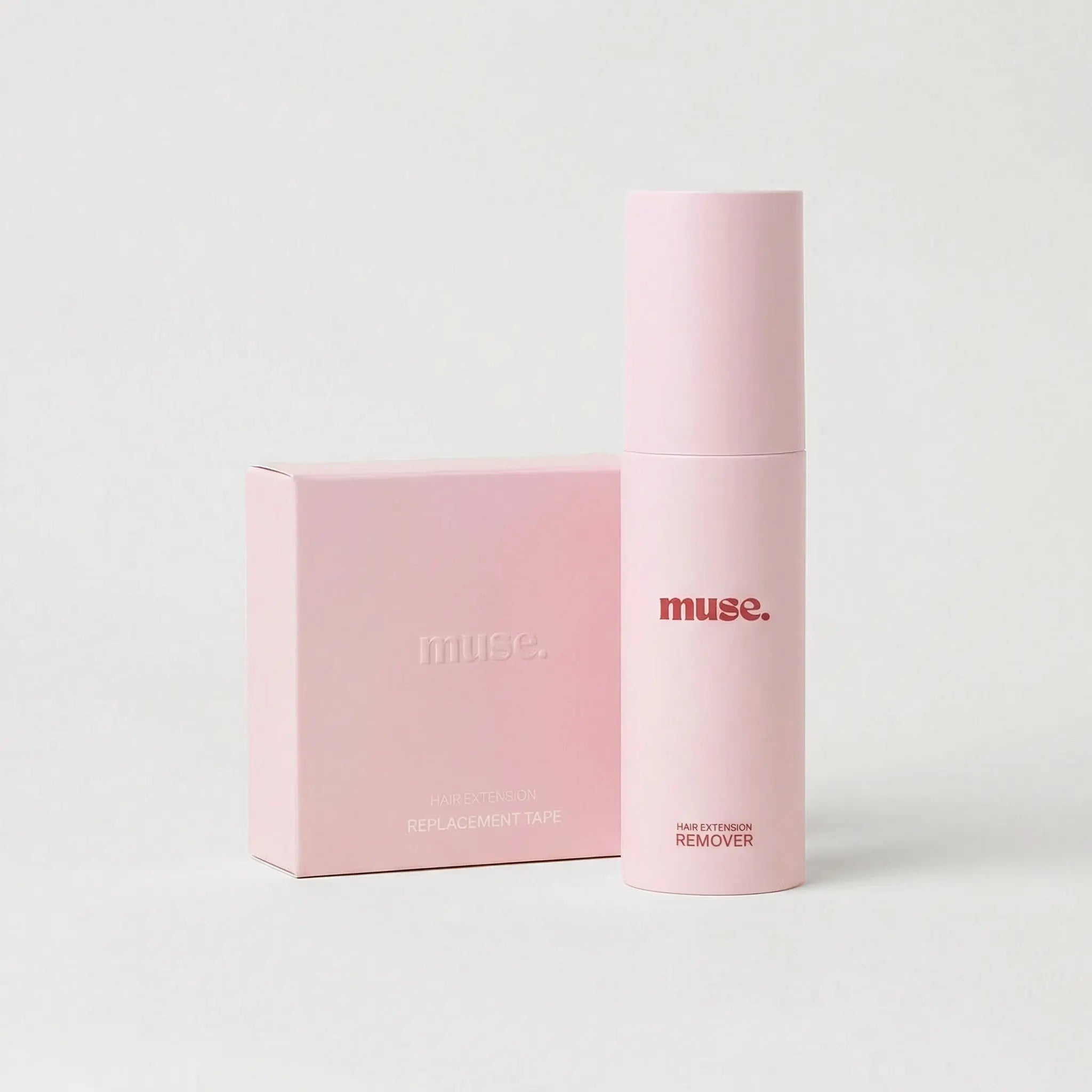 Pink bottle and matching box of Muse hair extension remover with minimalist design on plain background