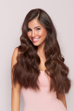 Smiling woman with long, wavy, shiny hair in warm brown tones showcasing Sample Swatch- Cocoa Brown 